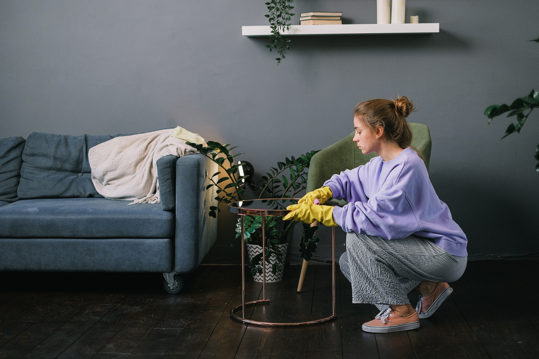 Female cleaning stylish living room in apartment